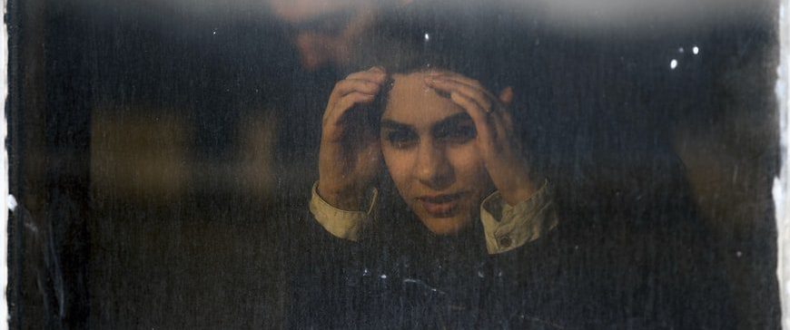 A sad woman looking out the window